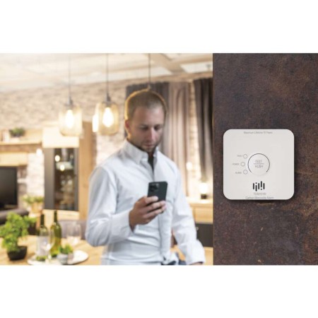 Uomo controlla rilevatore smart EMOS tramite app sul telefono